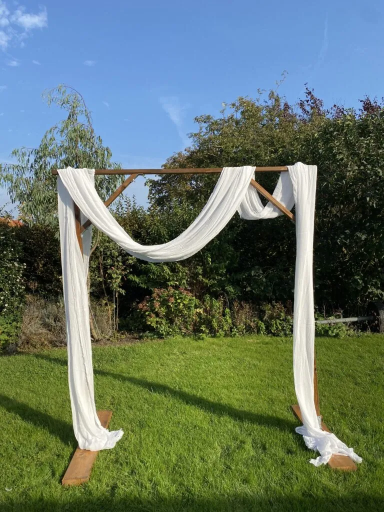 Houten backdrop met witte doeken in een tuin