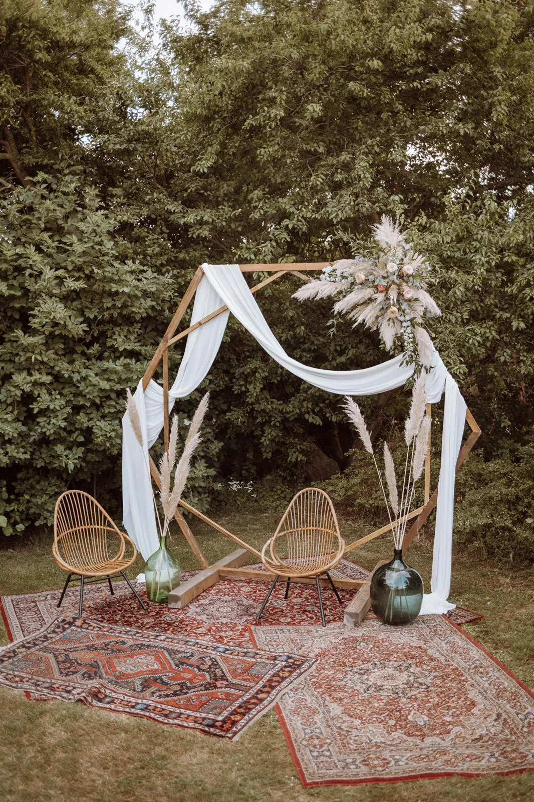 Backdrop met doeken en droogbloemen op een kleed in de tuin