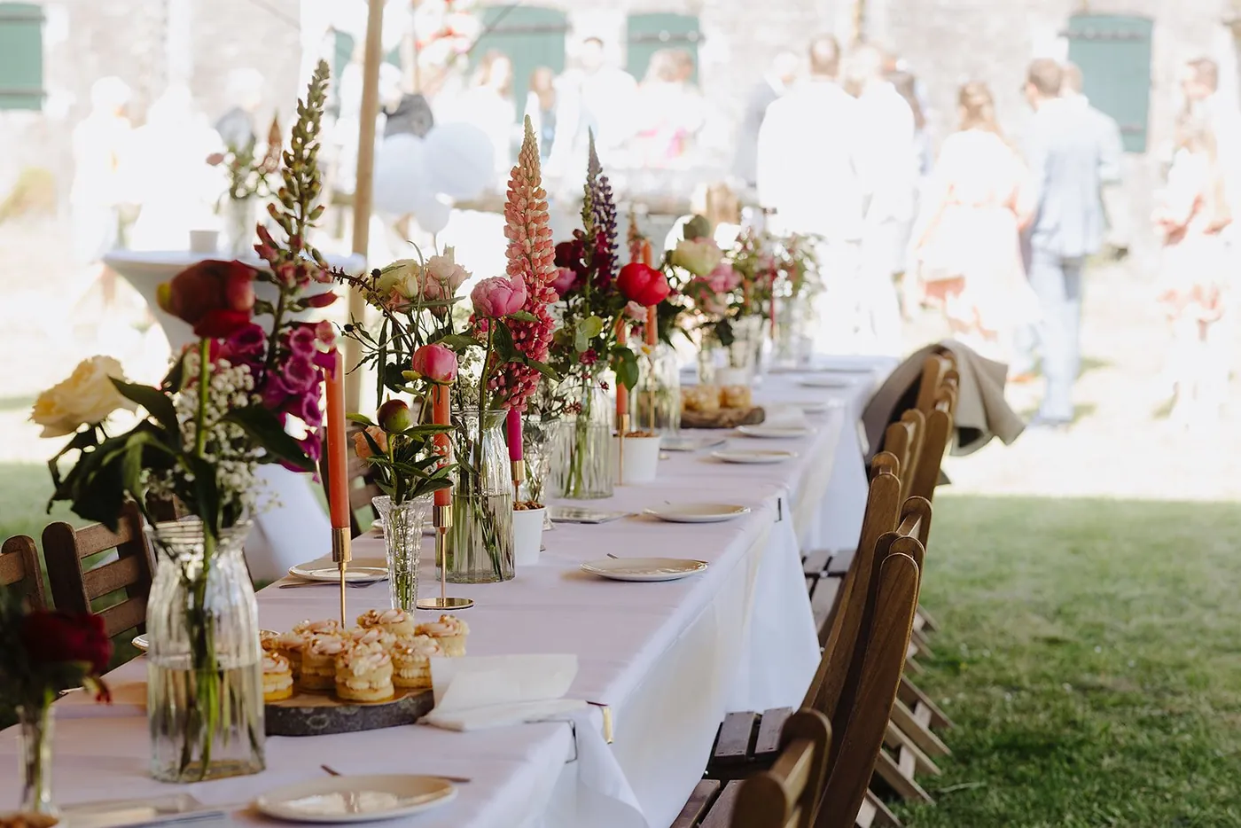 Lange trouwtafel met vaasjes vol verse bloemen