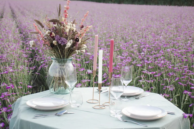 Tafel met vaas en kandelaren in een veld